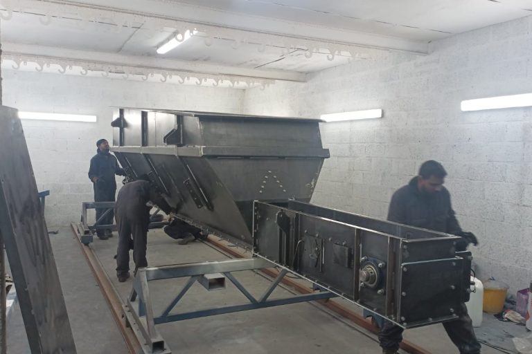 Ross Companies team assembling a hopper and feeder in our workshop